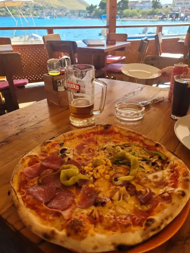 pizza on the terrace with a sea view in Grebastica