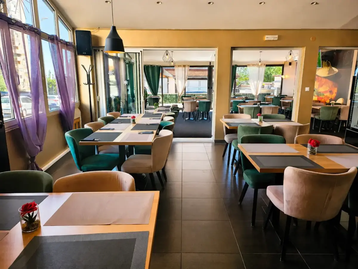 Interijer Pizzerije Victoria Sibenik s uredjenim stolovima i zelenim stolicama